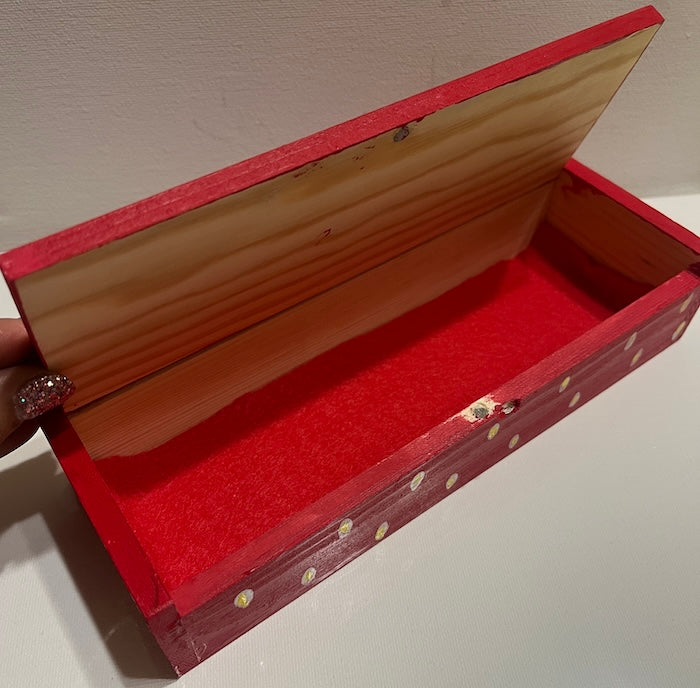 A sleek red hand painted wooden box