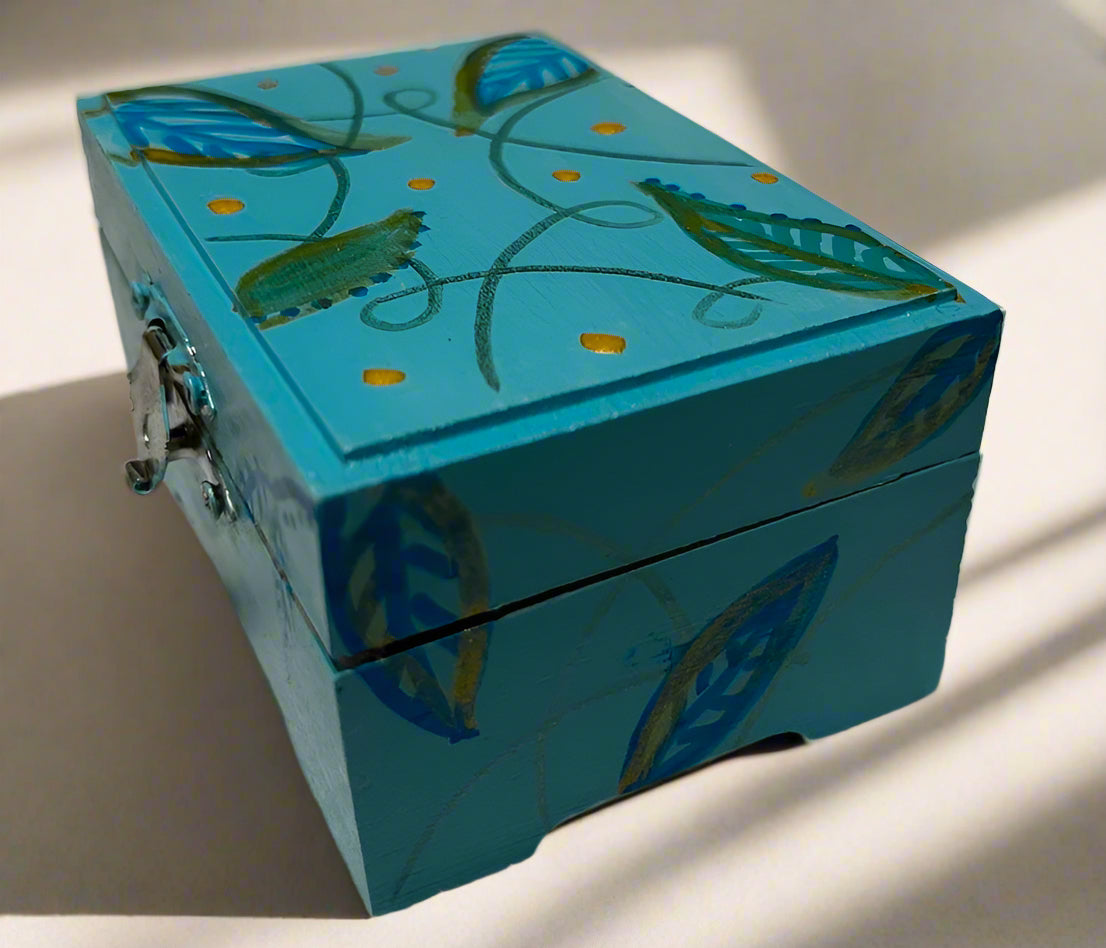 Blue wooden box with leaf patterns on a white background