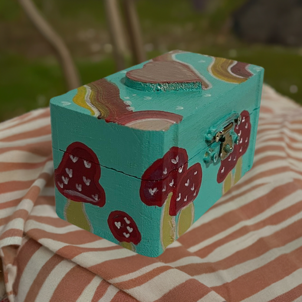 A small hand painted mushroom box with matching earrings.