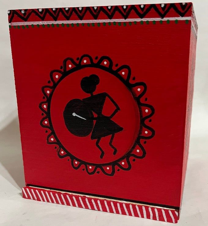 A red hand painted wooden tissue box cover with Warli art