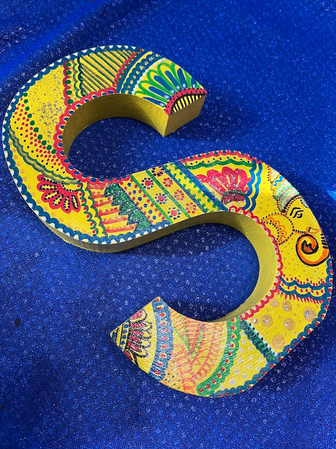A hand painted yellow wooden  letter 