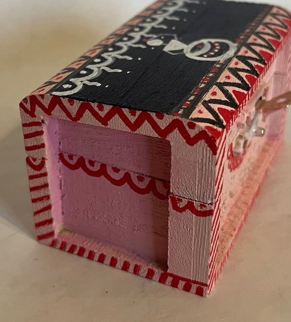 A small pink and black Warli art small gift box