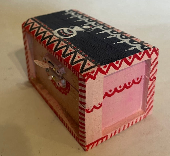A small candy box hand painted with Warli art shade of black and pink 