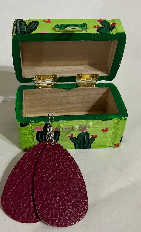 A green hand painted wooden box with earrings