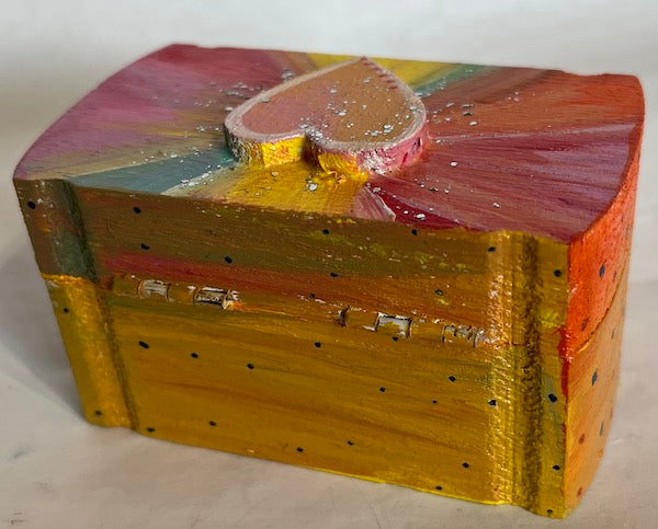 A colorful small handprinted wooden heart top box
