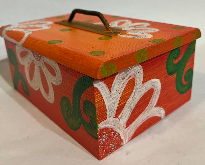 An orange hand painted wooden box with a removable lid