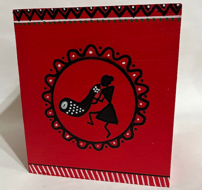 One side of a red hand painted Warli wooden tissue box 